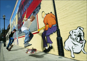 Actual skateboarders mimic those on a street mural