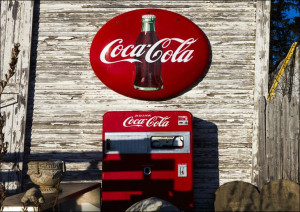 A vintage Coca-Cola sign and Coke machine outside