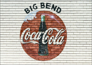 An old company sign appears on the wall of a Coca-