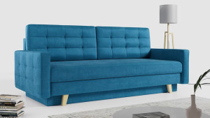 Niebieska sofa pikowana z luźnymi poduszkami, rozkładana