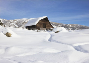 Heavy snow surrounds and lies a top a cabin in Steamboat Springs, Colorado.