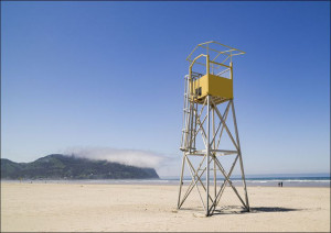 Lifeguard tower and a low, passing cloud on the beach of the small, Pacific