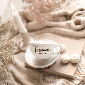 Biała filiżanka porcelanowa ze spodkiem 250 ml - napis Teściowa idealna ze złotym sercem dla teściowej na Dzień Matki