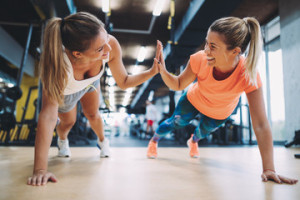 Fototapeta Siłownia Two sporty girls doing push ups in gym