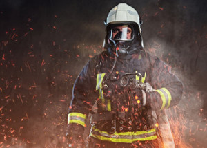 Fototapeta Straż A firefighter dressed in a uniform in a studio.
