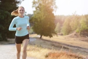 Fototapeta Lekkoatletyka Sporty girl in sportswear jogging, running and training outdoors on a sunny day in summer