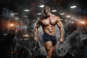Fototapeta Siłownia Muscular athletic bodybuilder fitness model posing after exercises in gym