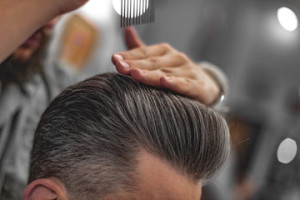 Fototapeta Fryzjerstwo Barber does hair styling. Men's Hair Care.
