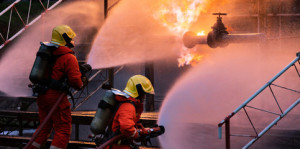 Fototapeta Straż Panorama Firefighter team using water fog spraying down fire from oil rig factory explosion