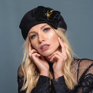 Czarny beret wełniany ze złotą gałązką.